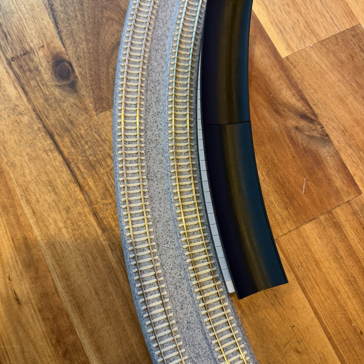 Real print: the curved station and the R381 curve from above, showing the platform following the track