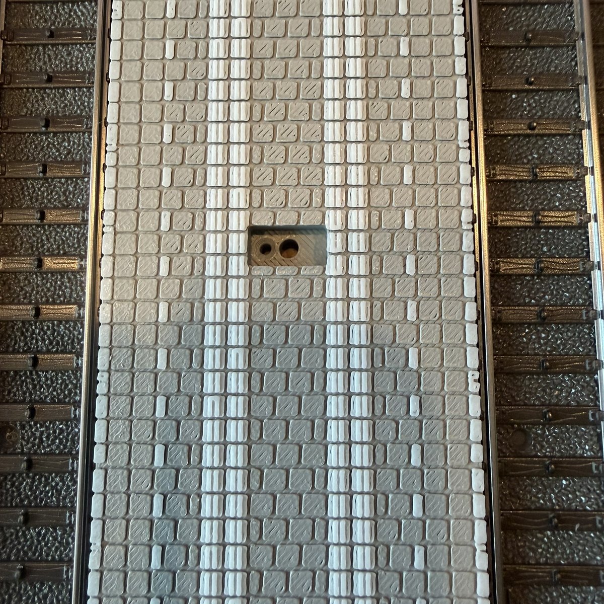 Real print: close-up of the two-colour deck, grey tiles with white guidance tiles and bands